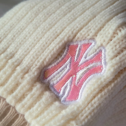 a close up of a knitted sweater with a pink and white design